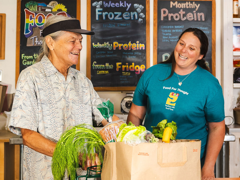Client and Food for Thought staff smiling while shopping in the food bank