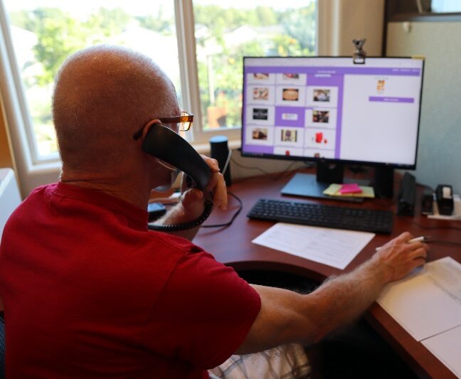 Volunteer working on computer and on phone