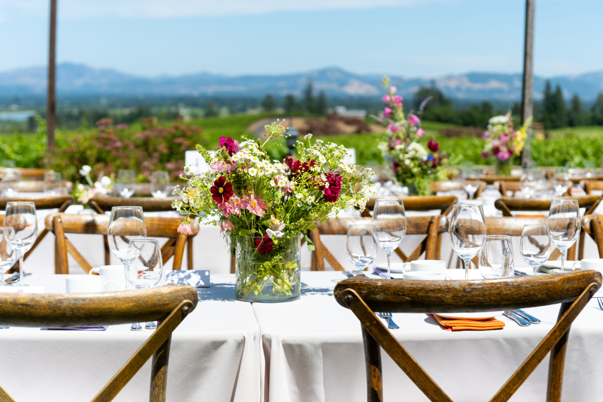 A beautiful flower arrangement on a table in front of breathtaking vineyard views