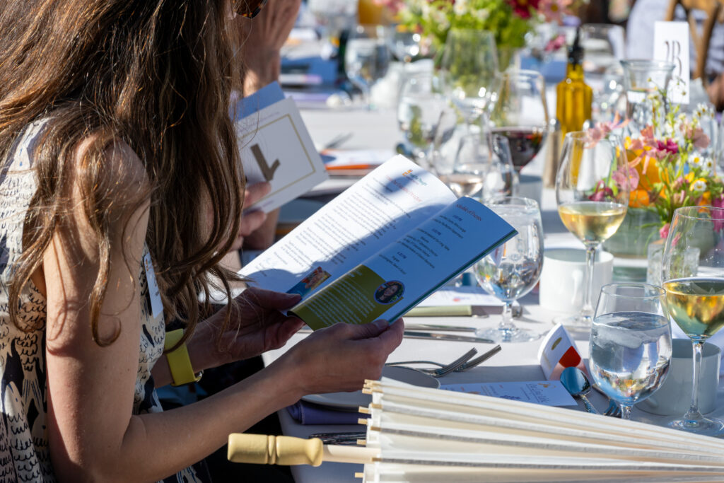 Guests read the Our Long Table auction program