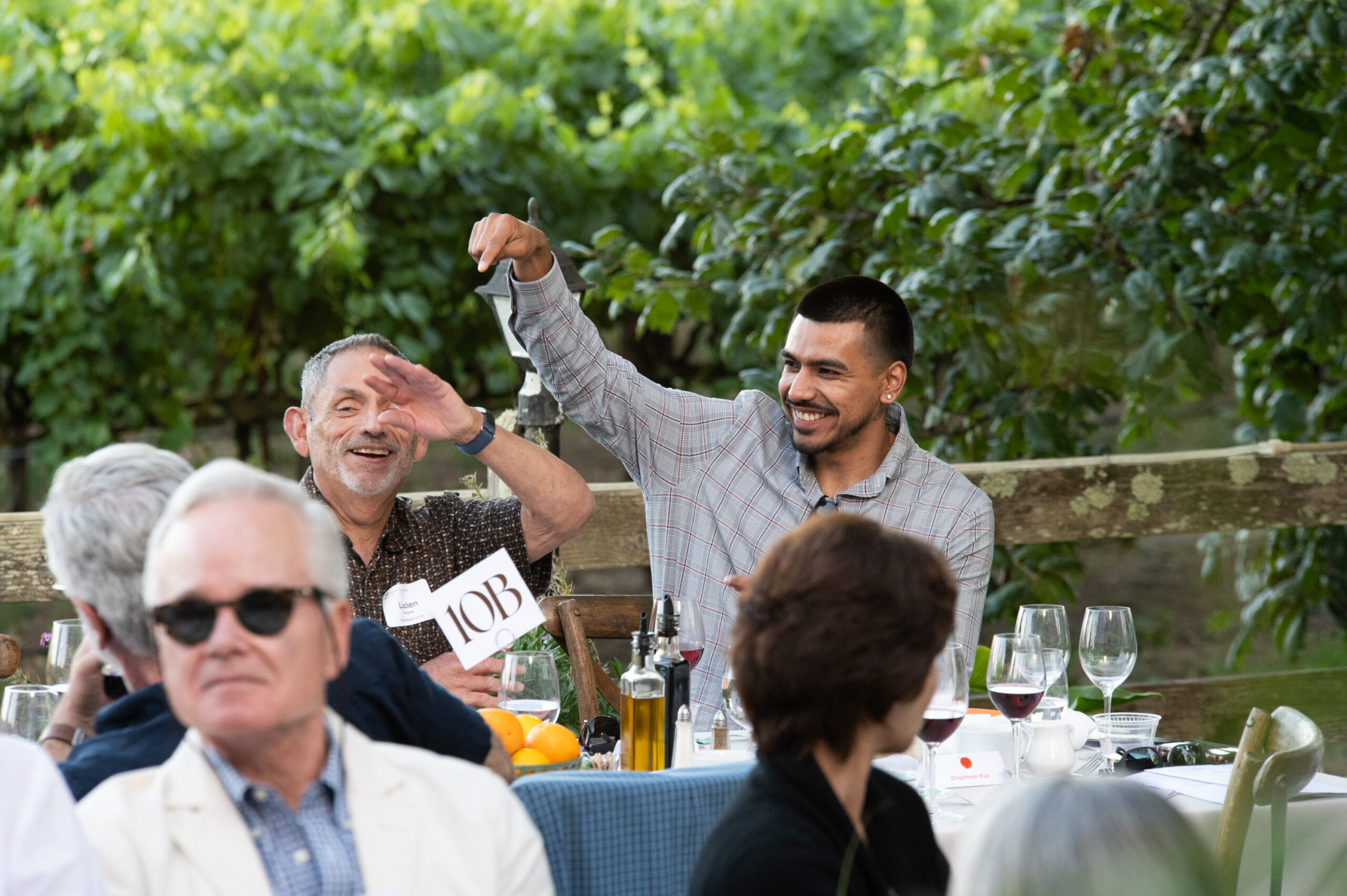 Two excited dinner guests smile and raise their arms